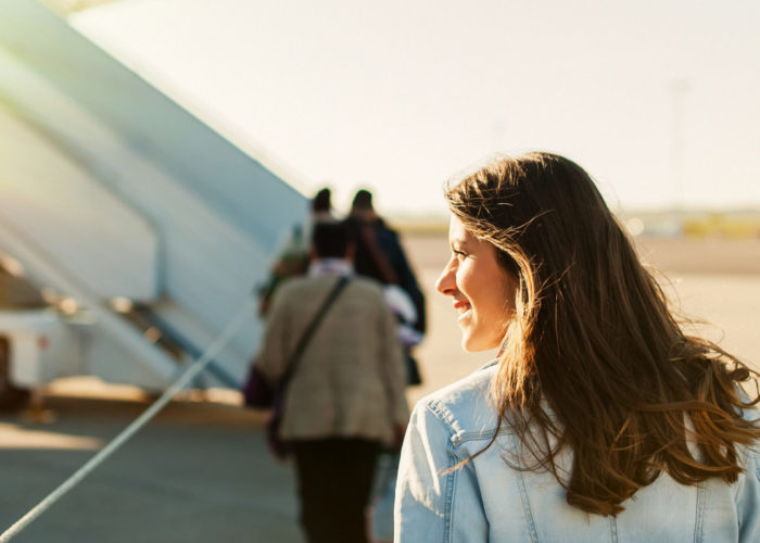 Woman walking towards a plane on the tarmac to board