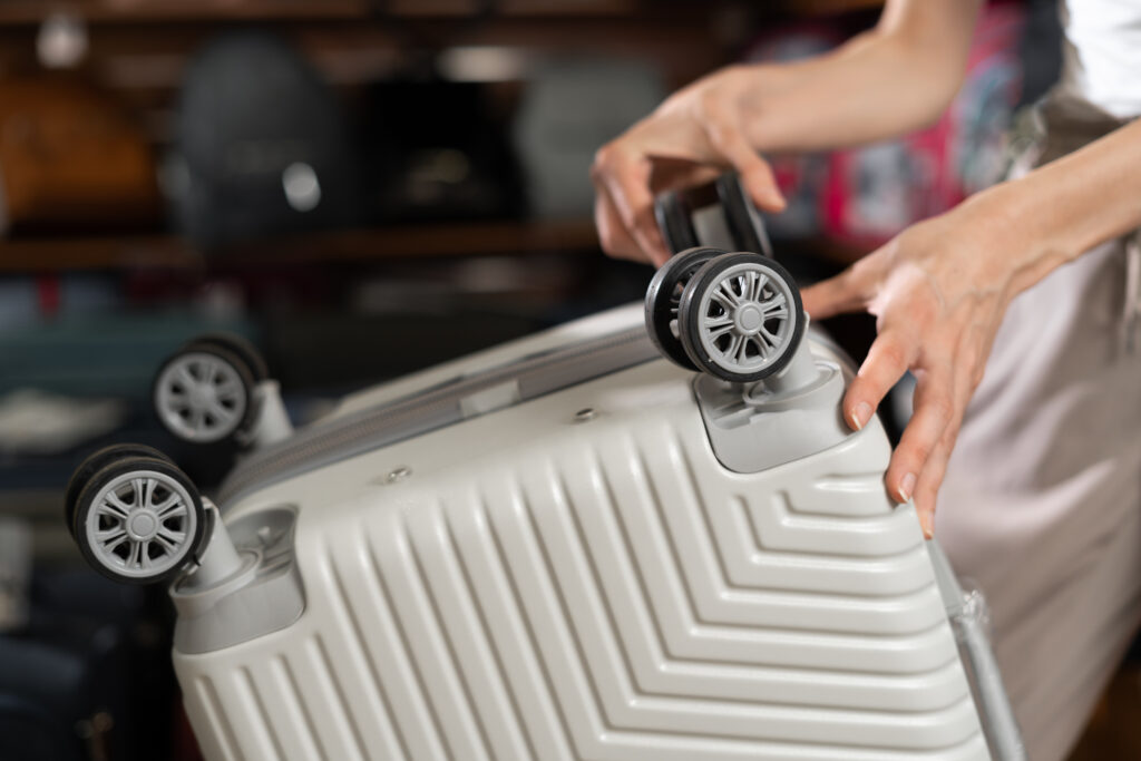 Close up of person inspecting the wheels on a suitcase