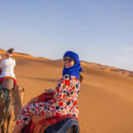 travelers ride on camels in shara desert Staff FOC trip to Morocco Uncovered (XMKC)