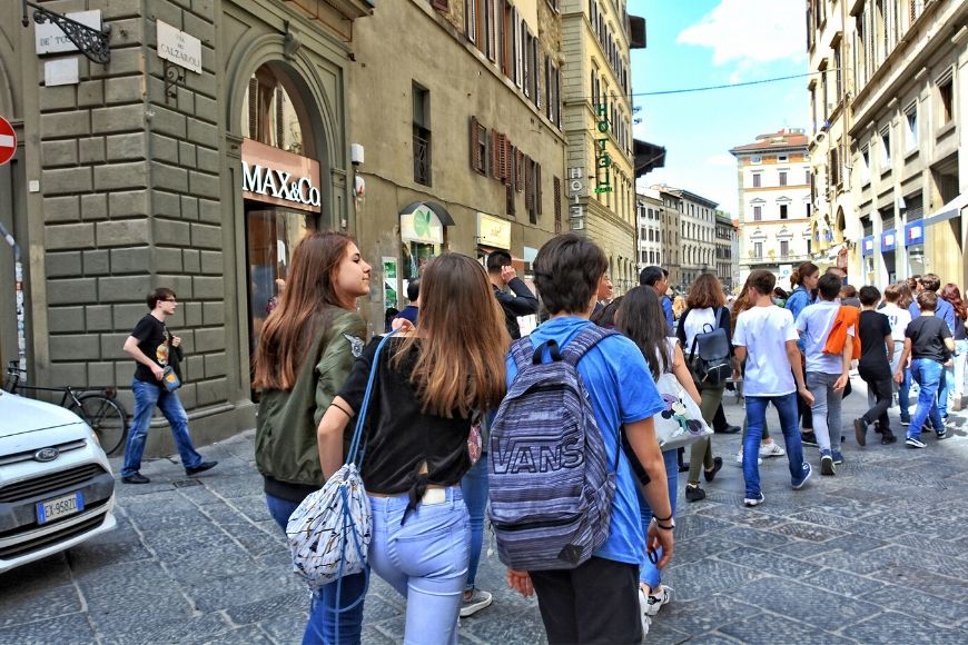 tourists with backpack and large purse in crowd.