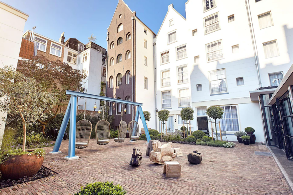 Swings and rocking horses in a courtyard at the Pulitzer Amsterdam
