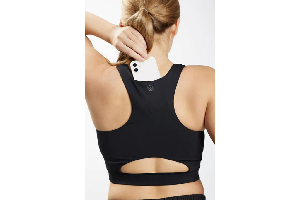 Woman modeling the Tomboy X Cutout Racerback Sports Bra and showing the hiding spot